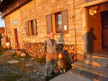 Porezen hut and its warden at sunset
